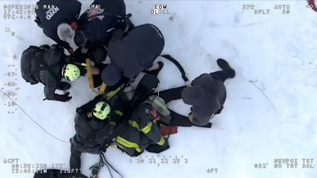 Aerial view of first responders assisting a person in the snow.